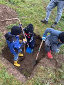Enfants de primaires creusant un trou pour un arbre fruitier