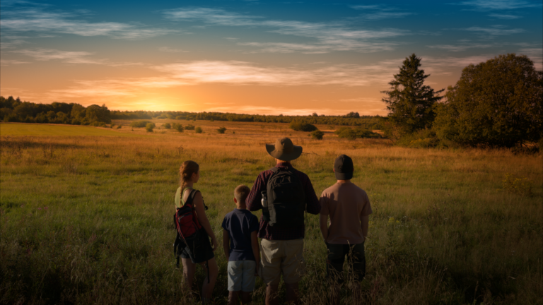 Homme et trois enfants de dos dans les Hautes Fagnes au couché du soleil