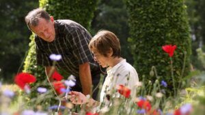Une femme et un homme en train d'observer des fleurs dans un champs